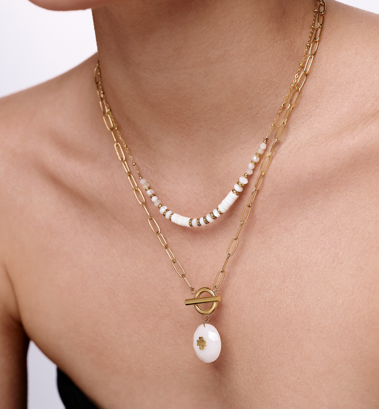 Zestaw złotych naszyjników z białymi koralikami i zawieszką z koniczyną ZN0115 - By Dziubeka