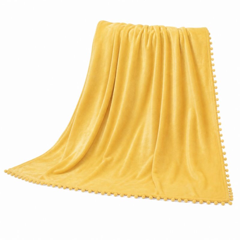 Koc narzuta z mikrofibry Pompie z pomponami Spod Igły i Nitki 150 x 200 cm musztardowy 1 szt.